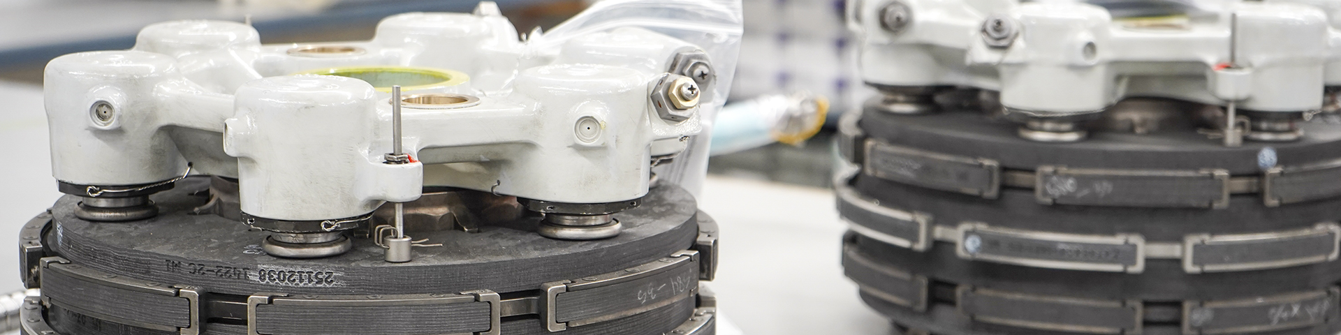 Close-up of aircraft components, likely parts of an engine or similar mechanical system. The parts are placed on a workbench, suggesting they are being inspected, repaired, or prepared for assembly.